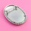 Handmade oval scene stitched brooch back