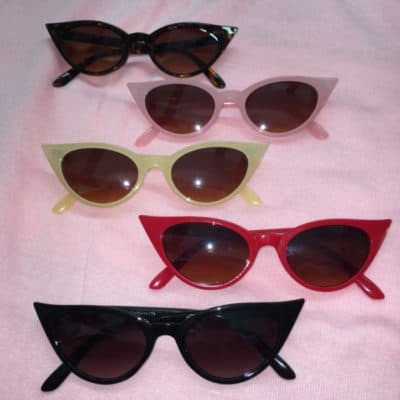 picture shows a selection of St Cyr cat eyes sunglasses laid out on pink cloth.