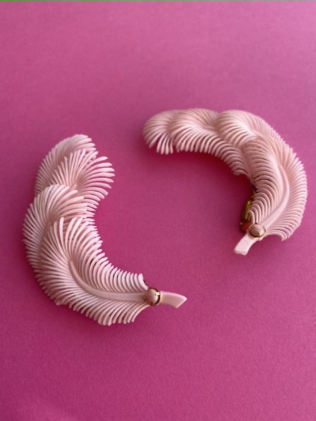 A pair of Vintage Feather Earrings in Pink which have four layers of feathers (plastic) and a rhinestone detail. The back has a clip on fastening and they are very pretty