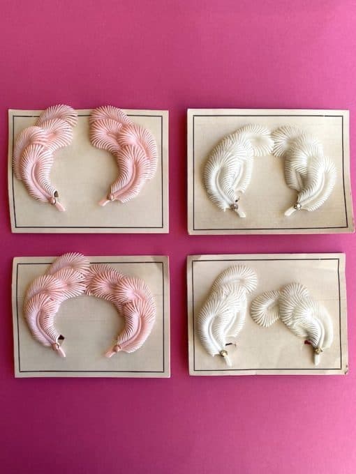 Image shows four pairs of vintage feather earrings made from lightweight plastic and on their original earring cards from the 50s or 60s. Each earring has four layers of feathers. They are very dainty.
