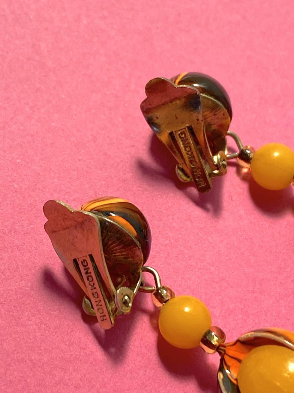 an image of the side view of a pair of 1960s Vintage Earrings in Orange made in Hong Kong