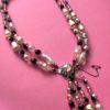 an image of a Vintage glass necklace with double strand and four drop strands on a pink background