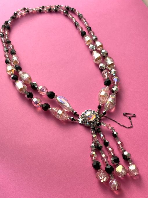an image of a Vintage glass necklace with double strand and four drop strands on a pink background