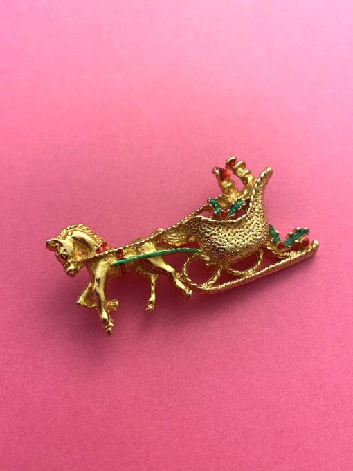 image of a vintage brooch depicting a sleigh and horse