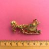 image of a vintage brooch depicting a sleigh and horse with ruler for measurement